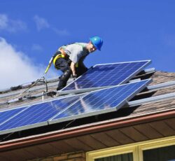Man,installing,alternative,energy,photovoltaic,solar,panels,on,roof